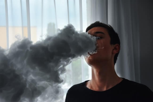 a man blowing smoke cloud