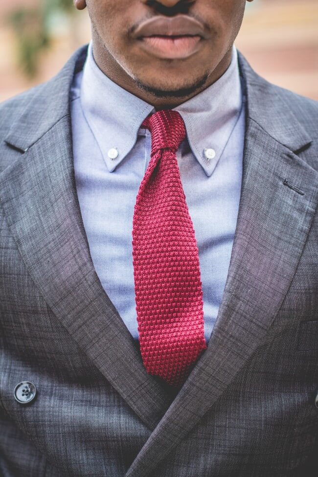 man in suit with a red knitted tie