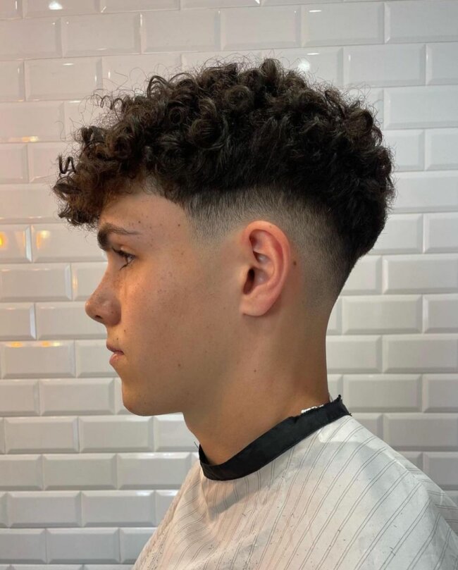A unique and sophisticated curly low fade haircut. 