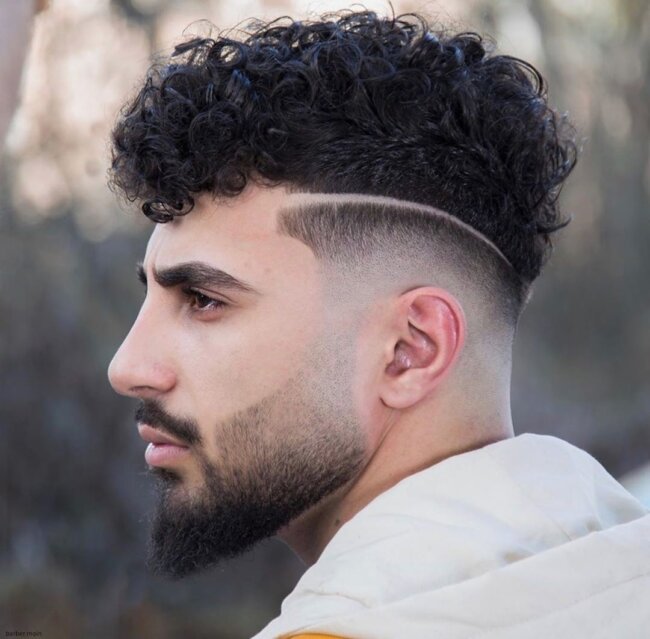 A unique and casual look with a curly top fade haircut. 