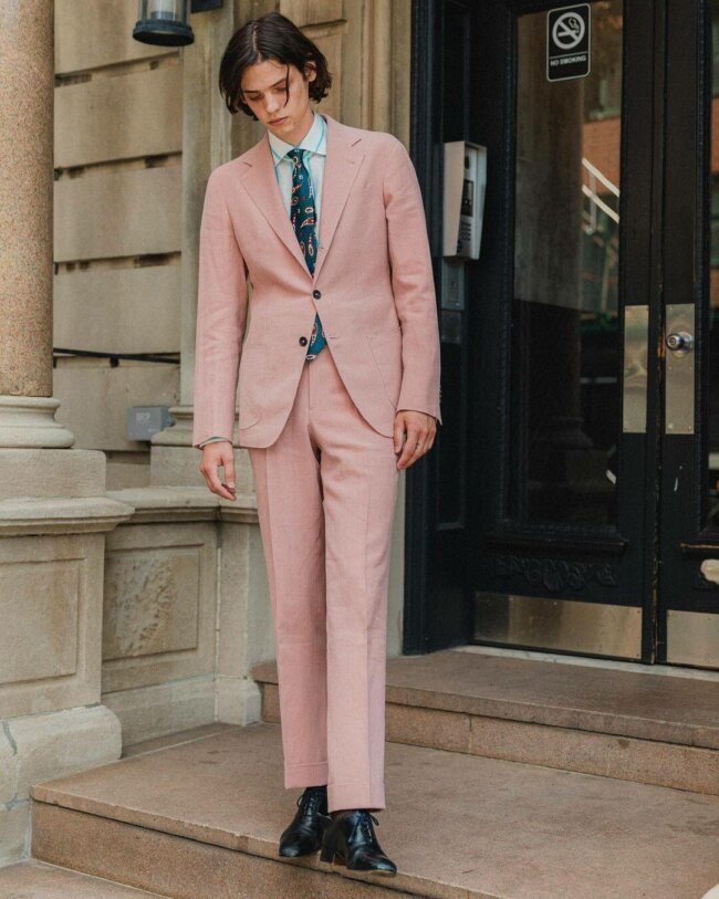 A relaxed outfit featuring a light pink suit. 