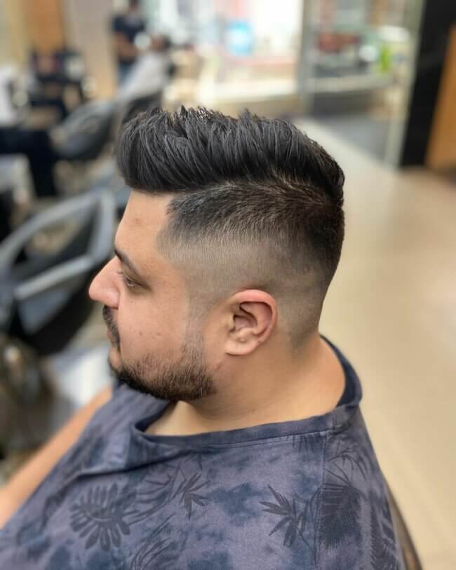A refined haircut featuring high fade with textured hair. 